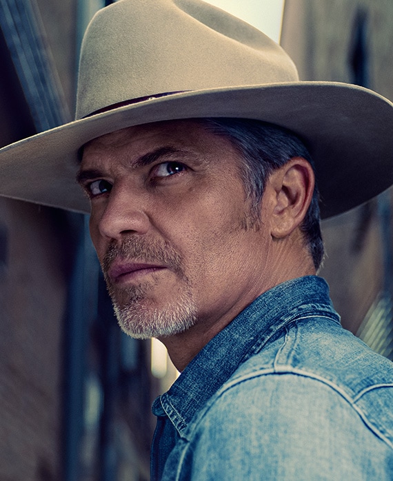 Timothy Olyphant headshot wearing a denim shirt and cowboy hat