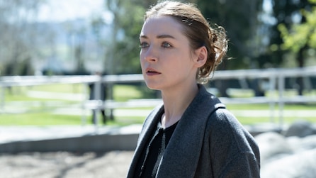 Emily standing outside and wearing a gray coat.
