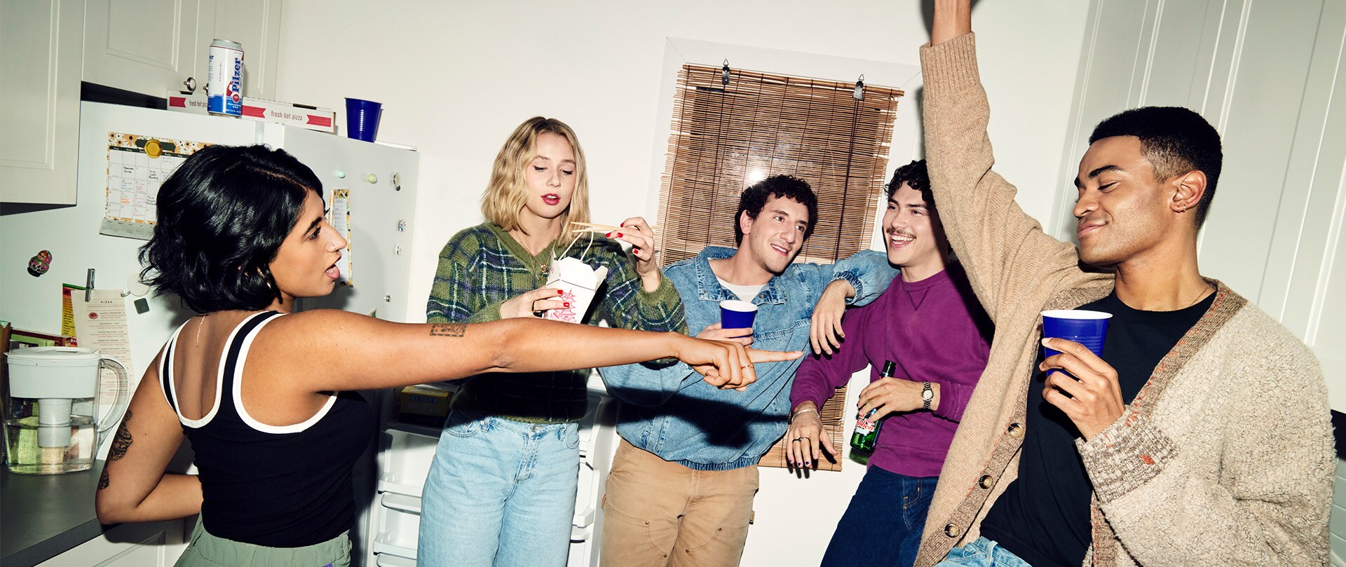 The cast from FX's Adults hanging out in the kitchen.