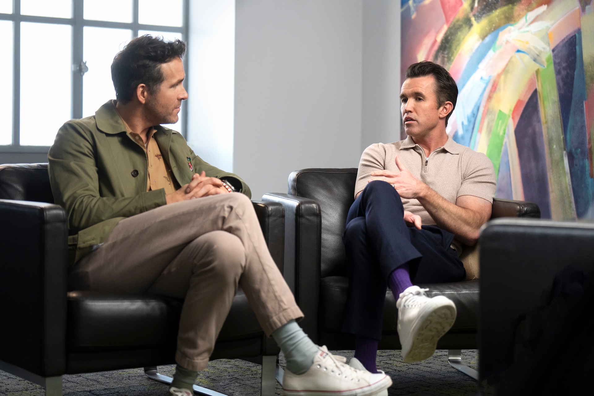 Rob and Ryan sitting on next to each other and chatting.