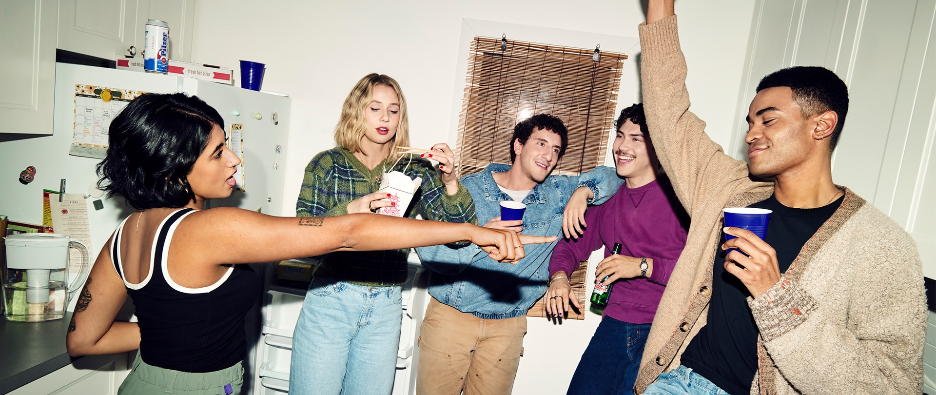 The cast from FX's Adults hanging out in the kitchen.