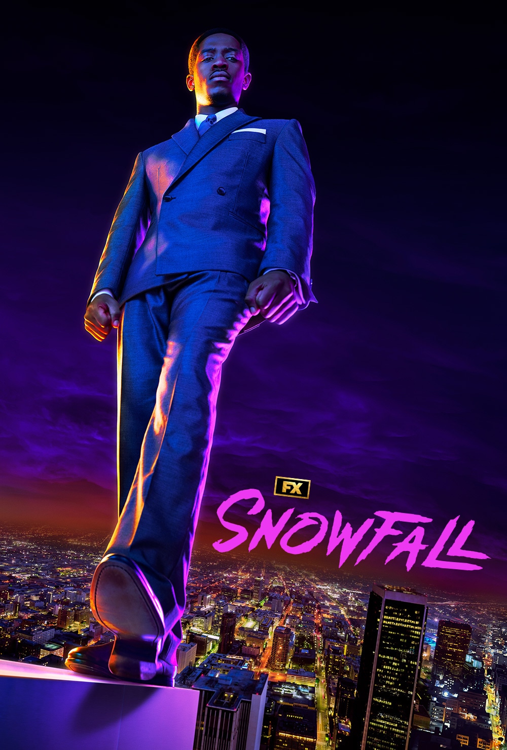 Franklin Saint wearing a suit standing on the ledge of a tall building with the city in the background