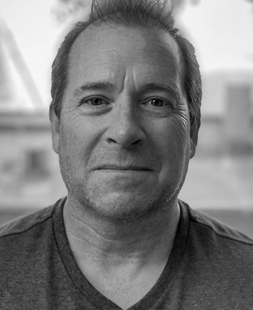 Jeff Luini headshot in black and white wearing a v-neck shirt