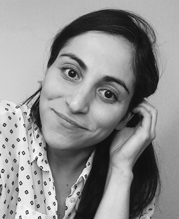 Black and white headshot of executive producer Sarah Naftalis, wearing a white patterned blouse. 