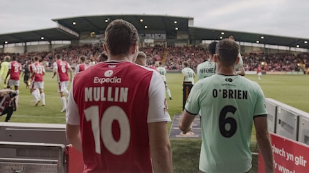 The back of two soccer players wearing jerseys with the numbers 10 and 6