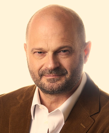 Brad Simpson headshot white button down with a brown corduroy suits