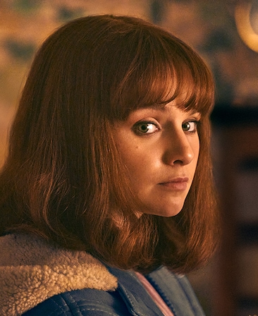 Lola Petticrew as Dolours Price in FX's Say Nothing wearing a coat looking off to the side.