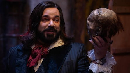 Laszlo holding a skull and looking at it.