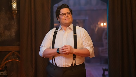 Guillermo wearing a white button down shirt and suspenders. 