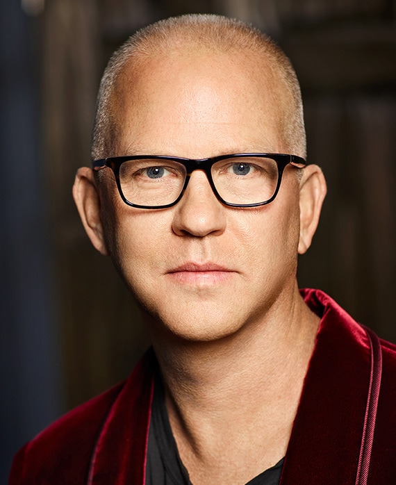 Ryan Murphy headshot wearing a red jacket and black glasses