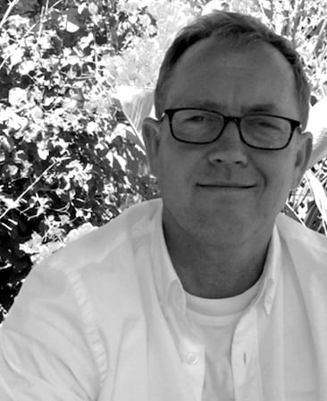 Chip Vucelich wearing white shirt under white button down outside in black and white headshot