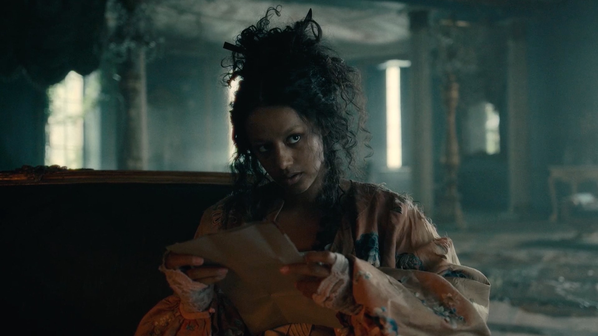 Estella sitting down at table wearing a peach dress