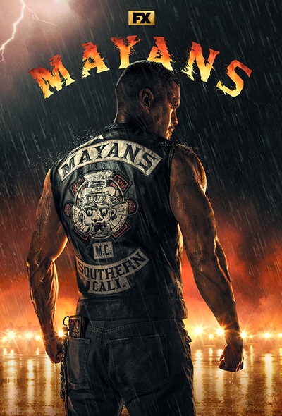 JD Pardo in front of fire and motorcycle gang with back turned to show biker vest in Mayans MC