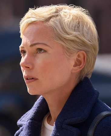 Headshot of Michelle Williams as Molly Kochan wearing a blue coat with her hair short and blonde.
