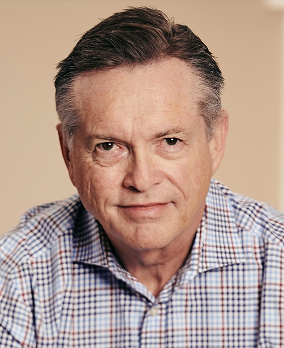 David Martin headshot in light blue plaid checkered button down with light peach background