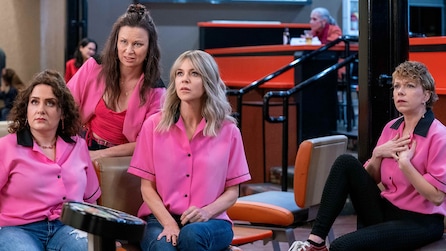 Dee, the waitress and three other ladies sitting down and wearing pink bowling shirts