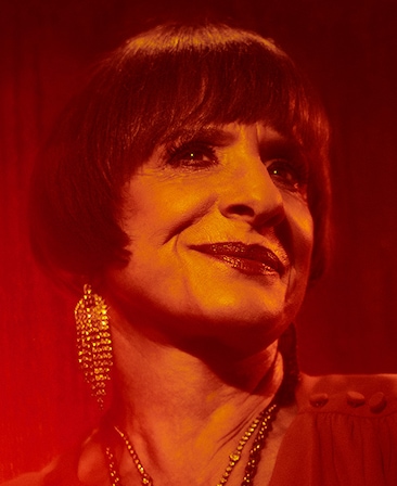 Headshot of Patti Lupone under red lighting 