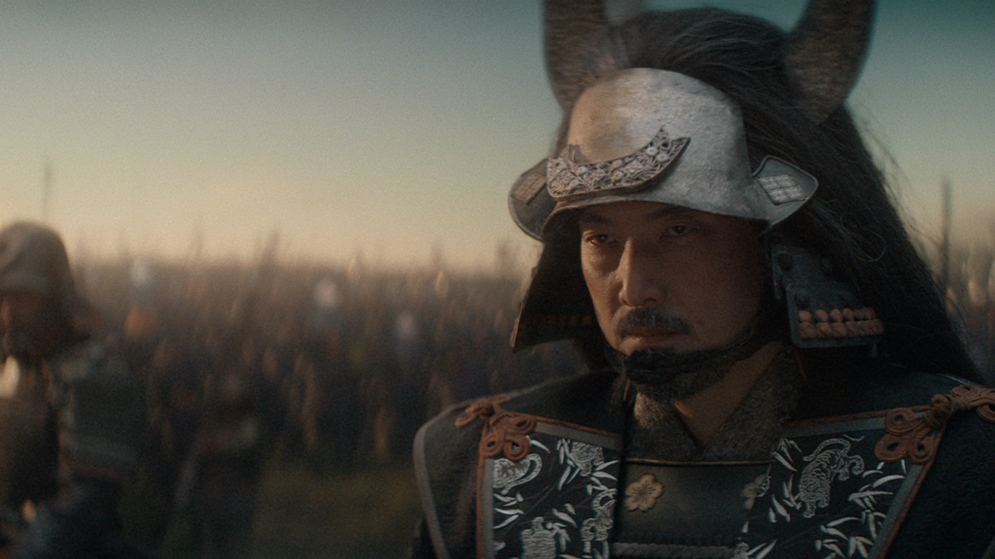 Close up of Ishido dressed in armor with an army behind him