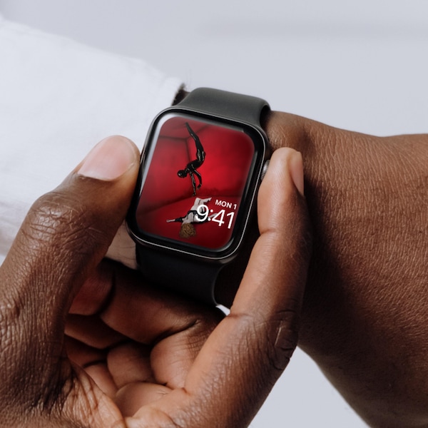 Man wearing Apple Watch with lock screen of pregnant woman on red floor with Rubber Man reaching for her in AHS Murder House