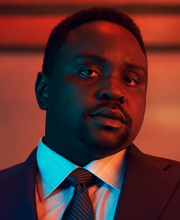 Brian Tyree Henry wearing a suit in red lighting for FX's Class of '09