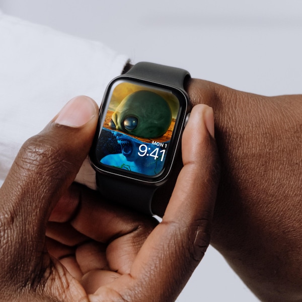 Man wearing Apple Watch with lock screen of half alien and monster screaming underwater from FX'S AHS Double Feature