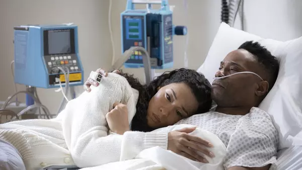 Woman laying on man in a hospital bed