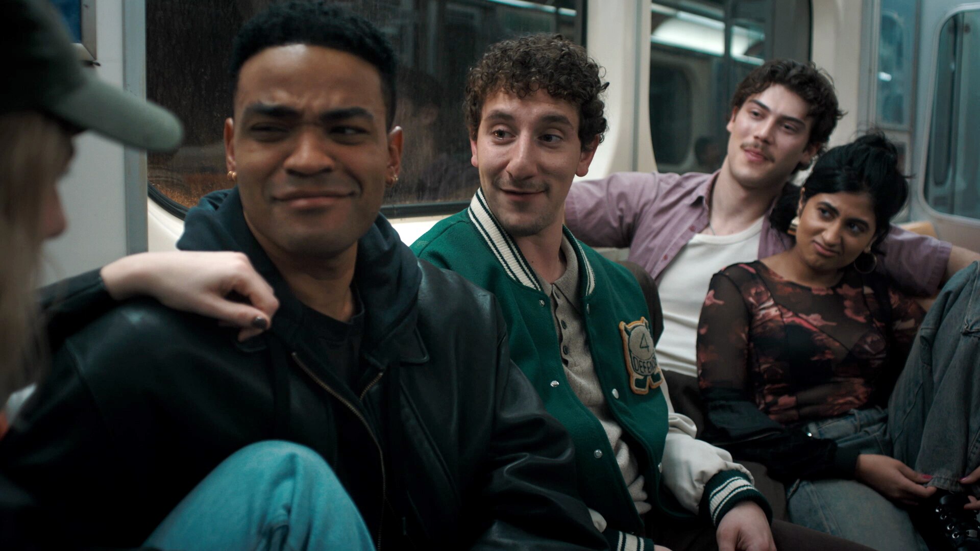Anton, Samir, Paul Baker, and Issa sitting on the subway.