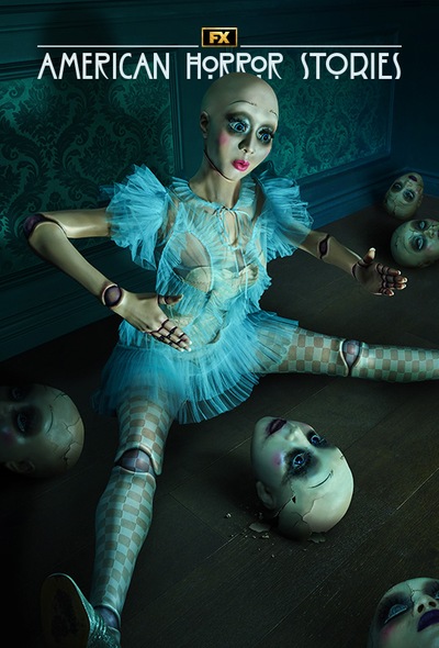 American Horror Stories Installment 2 doll in a blue dress sitting on the floor surrounded by broken doll heads