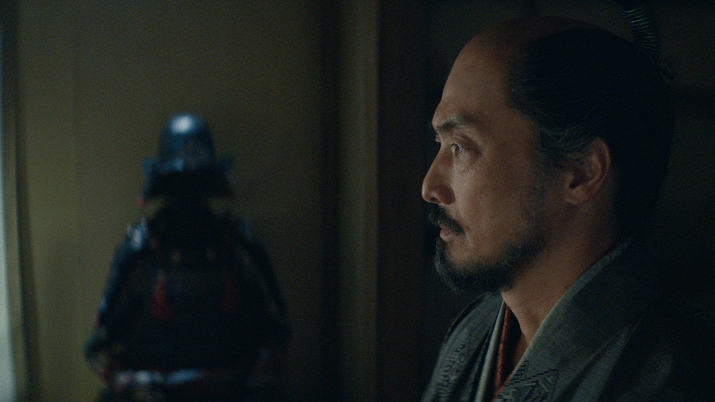 Side profile of Ishido with his battle armor in the background