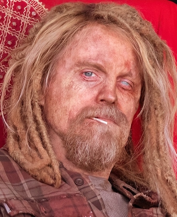 David Hornsby headshot wearing a red flannel shirt and a lollipop stick hanging out of his mouth.