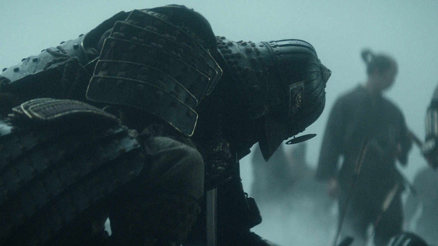 Samurai kneeling to cut off an enemy head on the battlefield