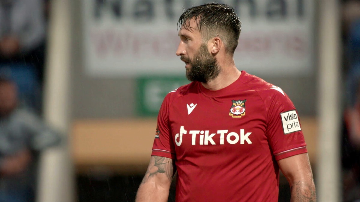 Wrexham player wearing a red Wrexham jersey that reads"TikTok"
