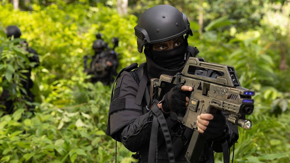 man in black gear holding a gun