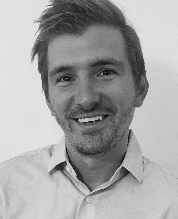 Headshot of Eric Kovtun, Executive Producer of FX's Grotesquerie, in black and white, wearing a light button up shirt.