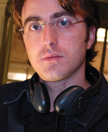 Scott Rosenbaum headshot wearing black headphones are his neck and glasses