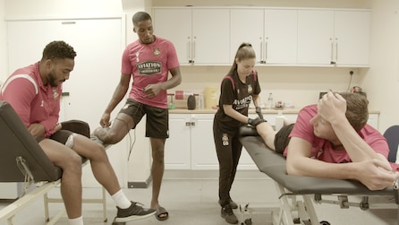 Soccer players in a training room getting massages