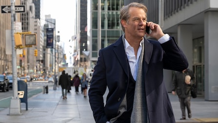 Man in winter coat on NYC sidewalk talking on the phone with people walking in FX's Fleishman Is In Trouble