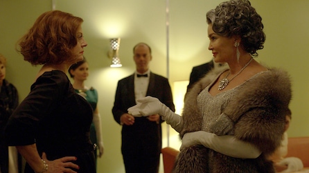 Jessica Lange as Joan Crawford wearing fur coat and gloves and Susan Sarandon as Bette Davis with hands on hips in FX's Feud