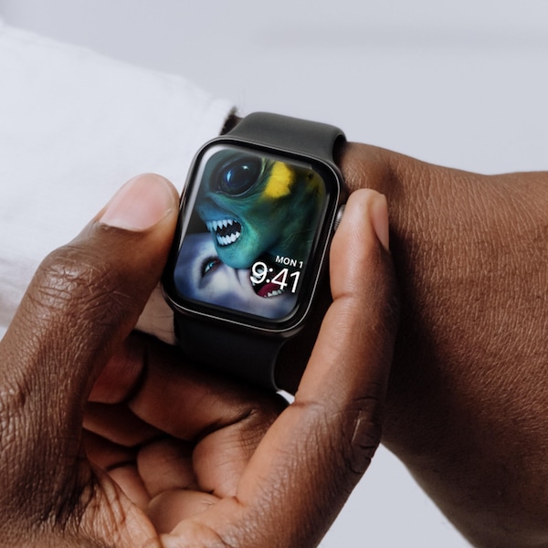 Man wearing Apple Watch with lock screen of fanged monster licking alien's neck from FX's AHS Double Feature