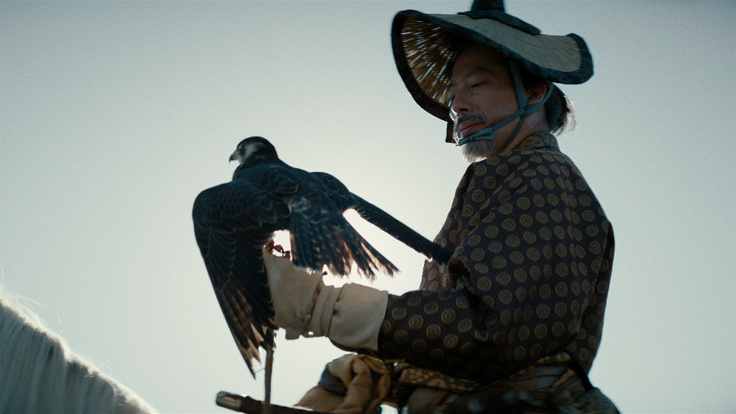 Toranaga holds his pet falcon while seated on his white horse