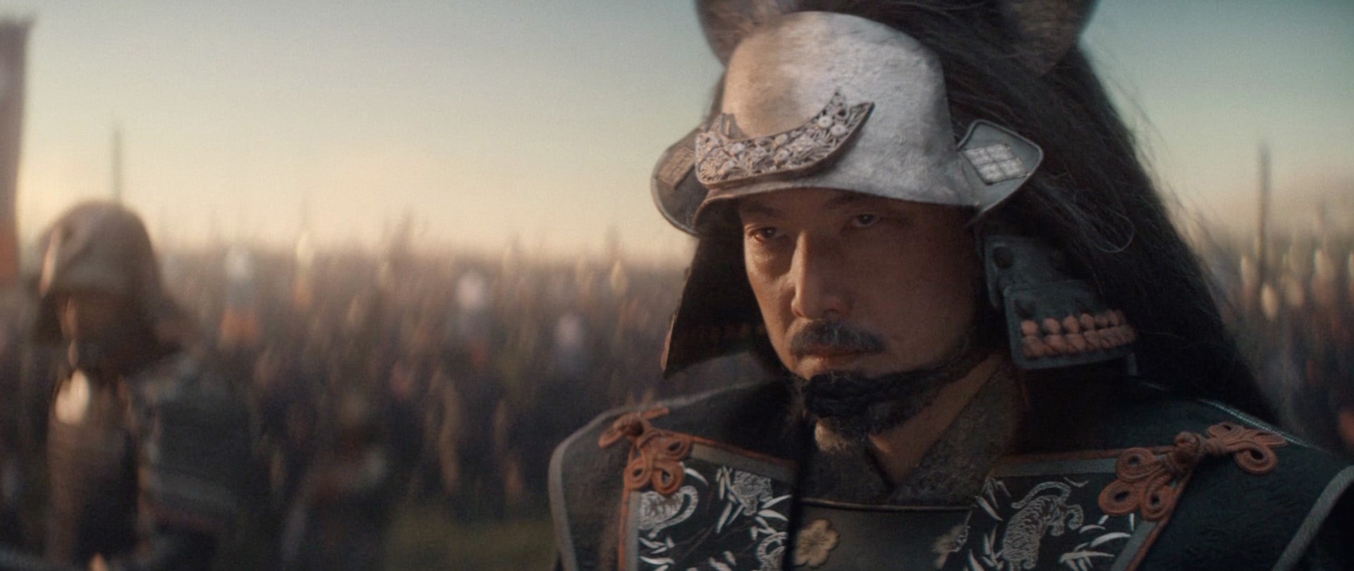 Close up of Ishido dressed in armor with an army behind him