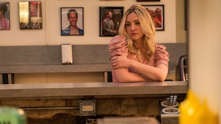 Abby Elliott as Sugar in pink puffy shoulder top hunched over countertop in restaurant in FX's The Bear