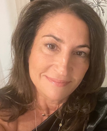 Headshot of Kathy Ciric wearing a black shirt and gold jewelry.