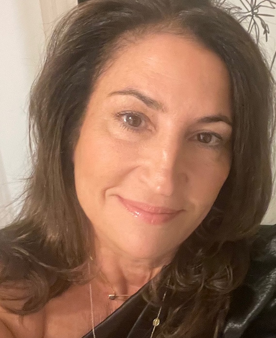 Headshot of Kathy Ciric wearing a black shirt and gold jewelry.