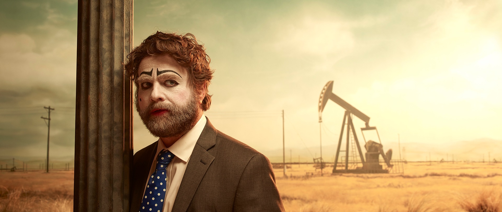 Zach Galafianakis as Chip Baskets for FX's Baskets in the middle of the Bakersfield desert, leaning on a city sign.