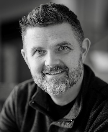 Black and white headshot of Bryan Rowland in a button up shirt
