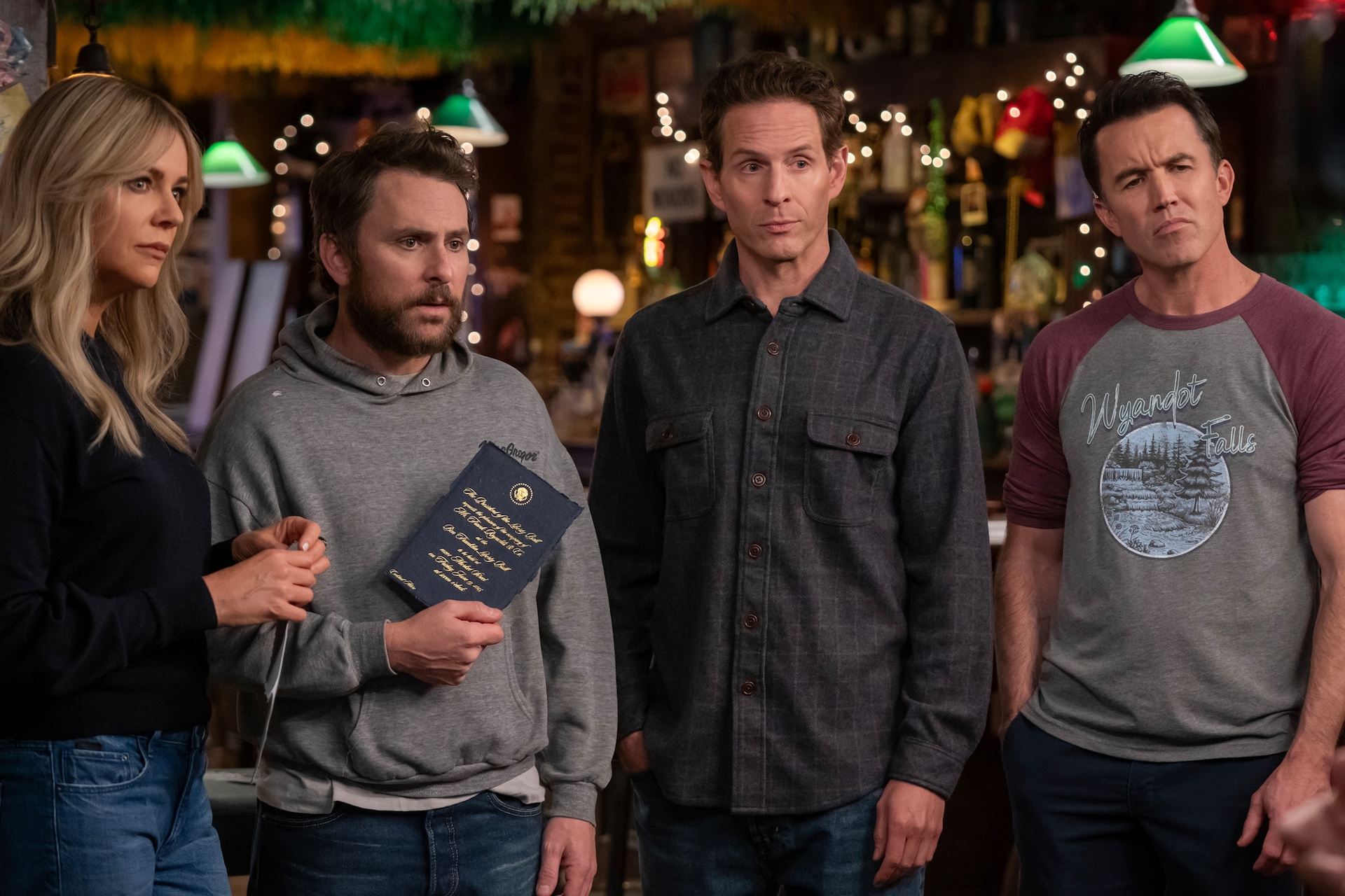 Dee, Charlie, Dennis, and Mac standing next to each other in a bar in FX's It's Always Sunny in Philadelphia