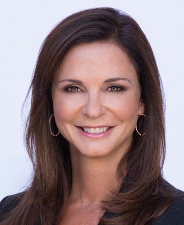 Headshot of Nissa Diederich, Executive Producer of FX's Grotesquerie, wearing black suit with gold hoop earrings.