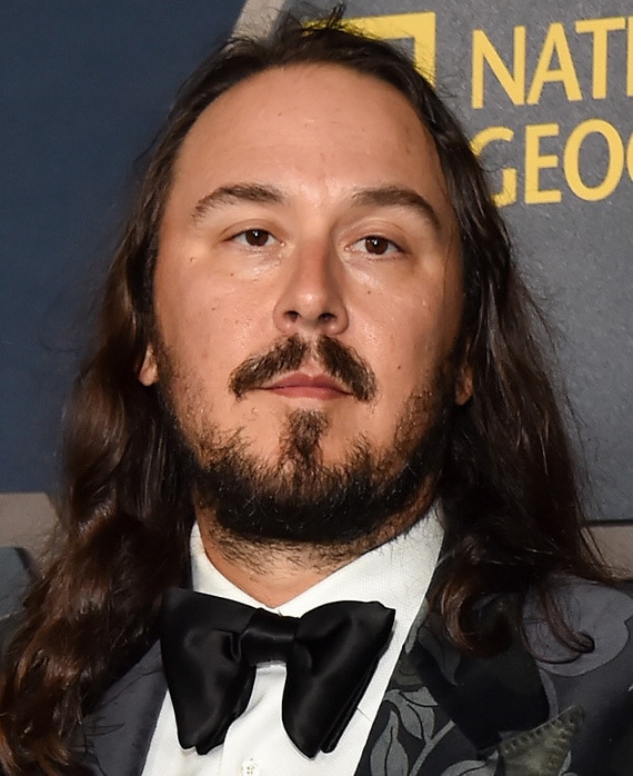 Executive Producer Kyle Newacheck headshot in a floral suit and bow tie.