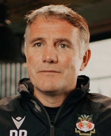 Phil Parkinson headshot wearing a black jacket with a Wrexham logo
